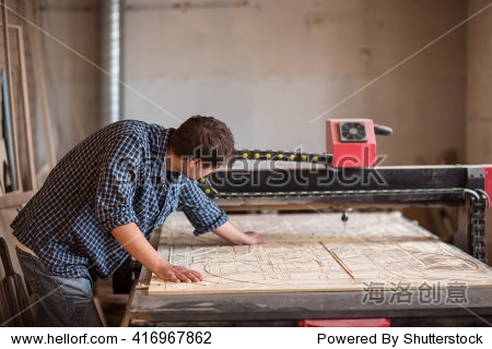 a man in a carpenter"s shop with a large cnc milling machines