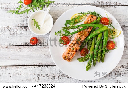 baked salmon garnished with asparagus and tomatoes with herbs.