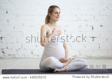 portrait of young pregnant yoga model working out indoors.
