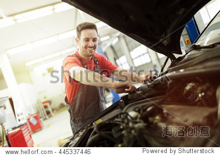 car mechanic fixing a car in garage at dealership