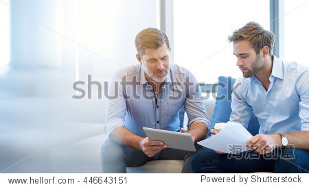 mature businessman using a digital tablet to <strong>discuss<\/strong> information