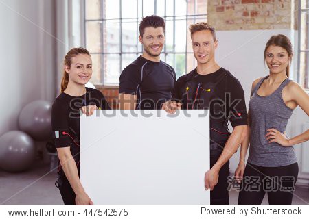 smiling young people, two men and two women, holding a blank