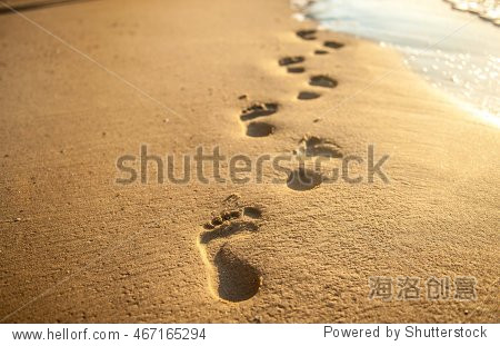 beach wave and footsteps at sunset time
