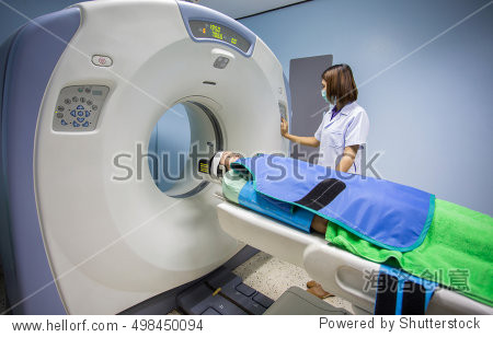 echnician mature female patient lying on a CT S