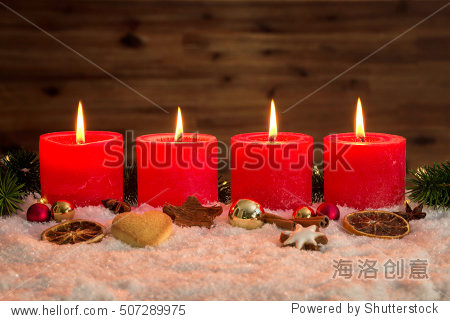 four red advent candles with four candles lit and christmas