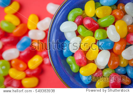 jelly bean candy sweets in bowl on red background