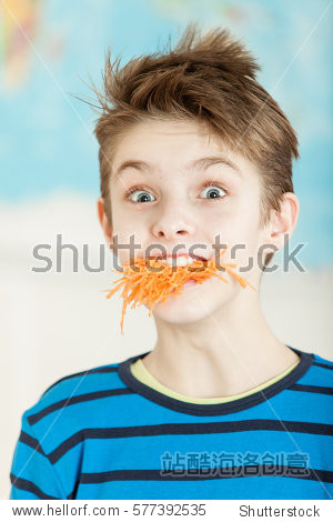 cute young boy with a mouth stuffed with fresh grated carrot