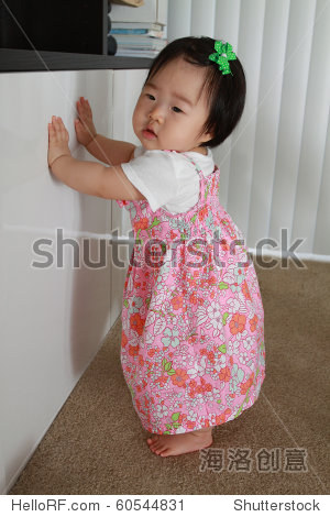 美丽的亚洲婴儿十个月大的女婴在粉红色的花裙