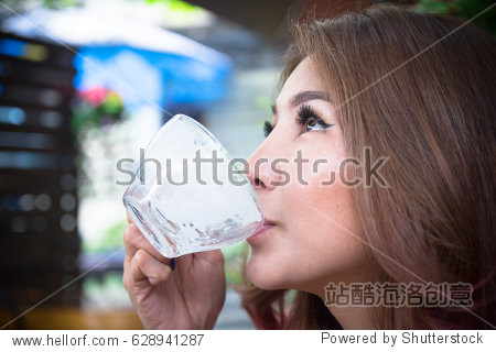 asian girl holding drinking bottle up empty glass of hot milk in