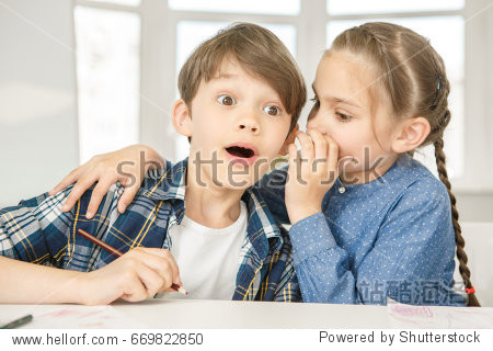 cute little boy looking surprised listening to his friend
