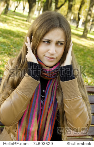 一个美丽的年轻女子的画像在公园长椅上坐着。