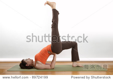 woman holds an extended bridge yoga pose