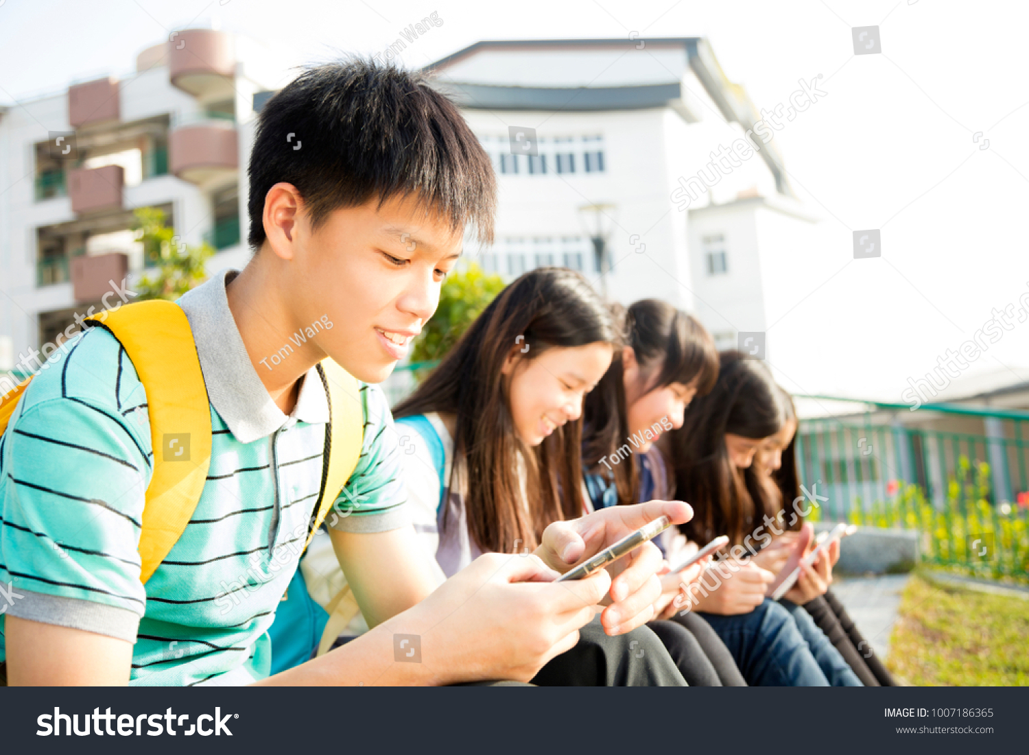 Teenage StudentsÂ sitting and using smart phone