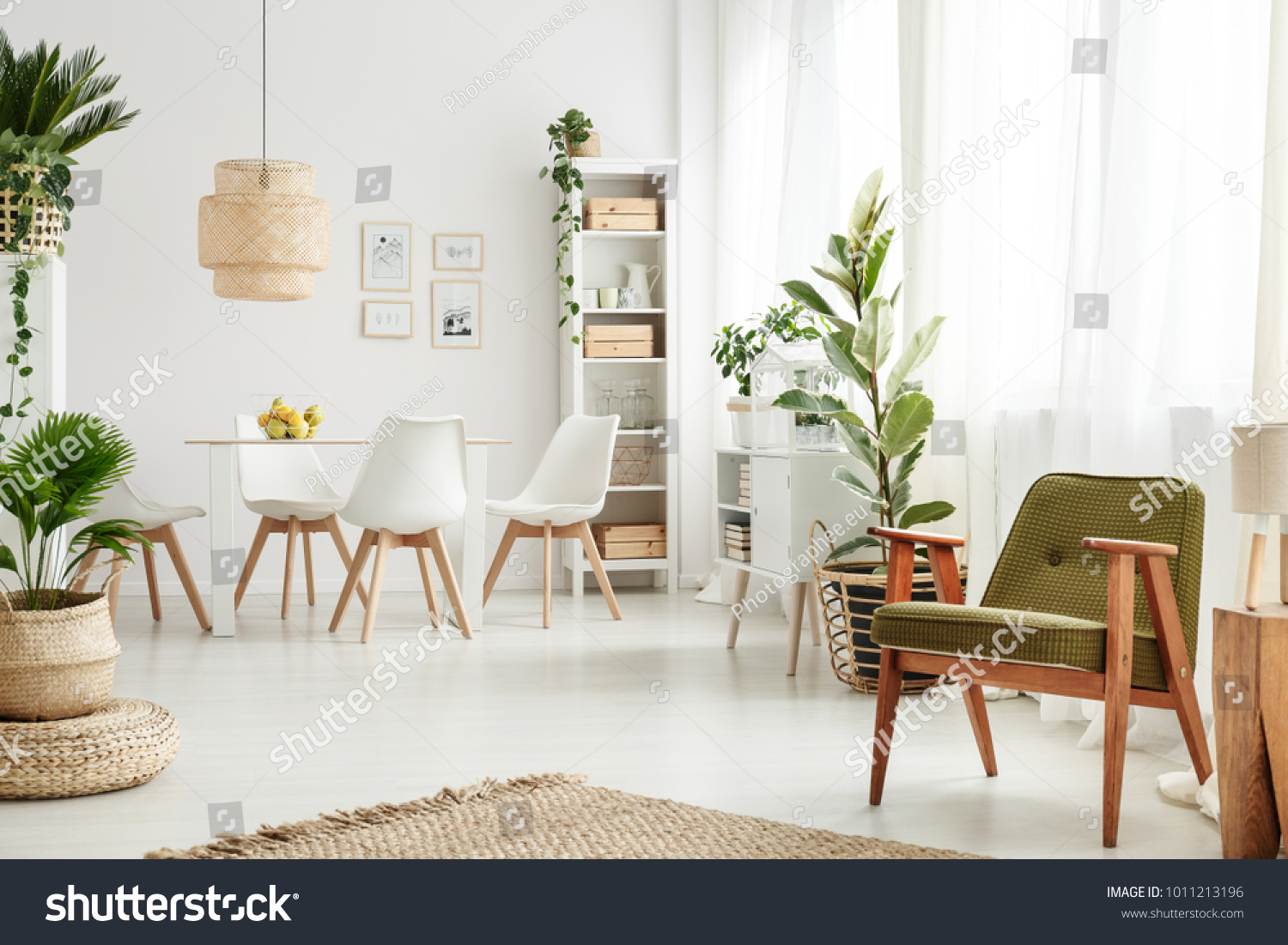 Botanic dining room interior with retro armchair rattan lamp above table white chairs and lots of plants