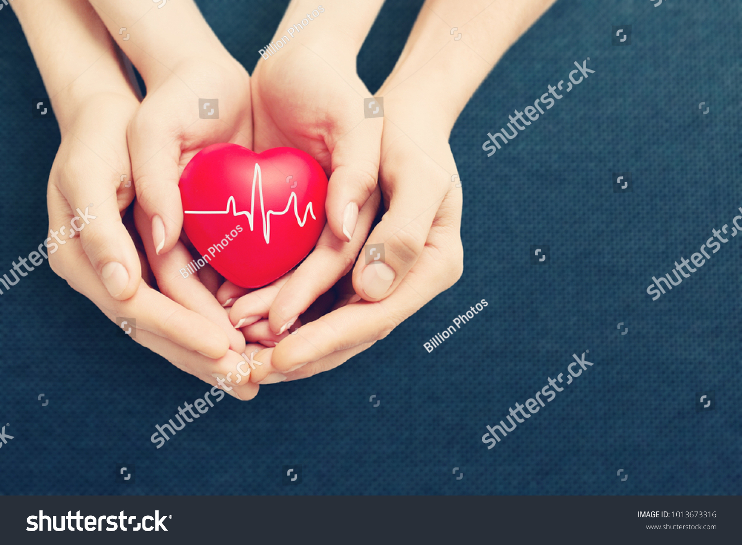 adult and child holiding red heart