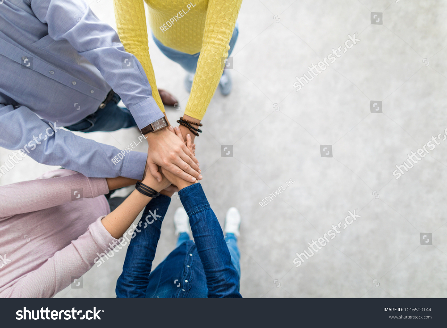 Close up top view of young business people putting their hands together. Stack of hands. Unity and teamwork concept.