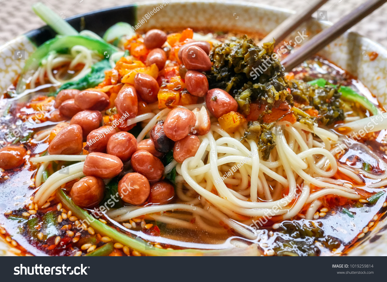 Spicy noodle soup with vegetables herbs peanuts and coriander popular in Yunnan Province shallow depth of field China.