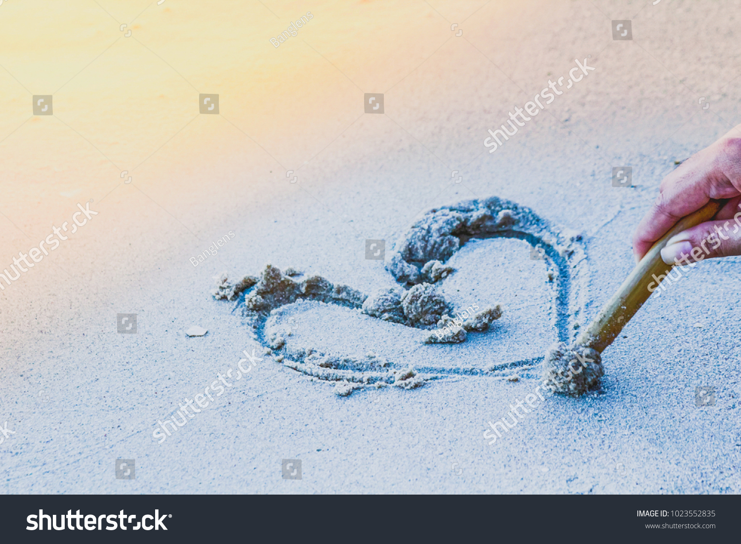 Draw a heart on the sand to a loved one on Valentine's Day. The Happy Couple on sunset.