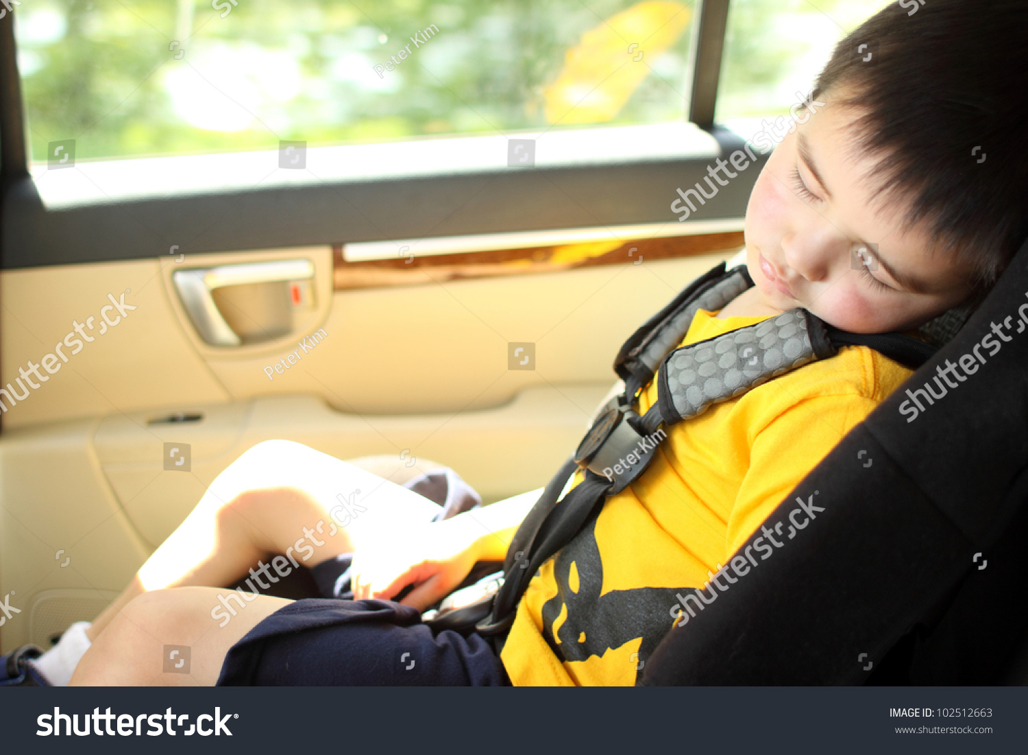 Toddler asleep in a child safety seat in a car.
