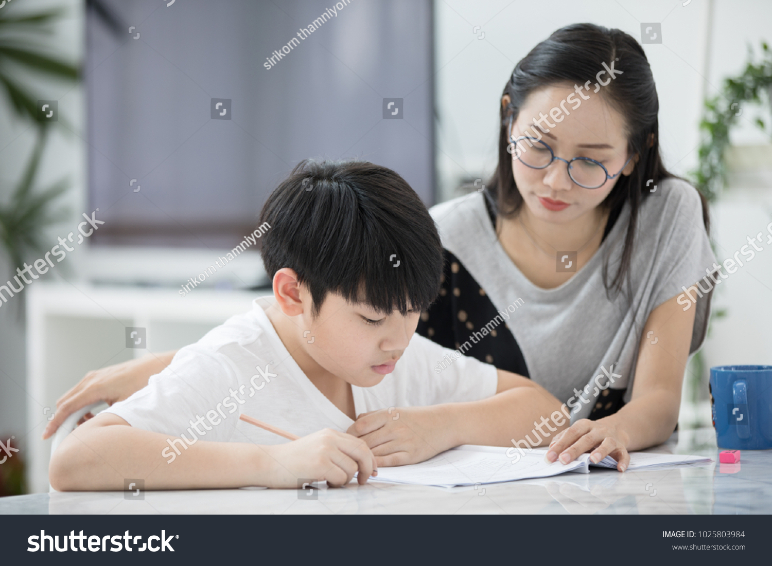 Asian boy with mother teaching and learning your homework at home 