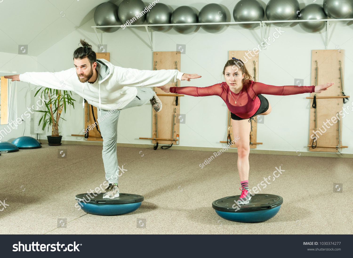 Young beautiful and attractive fitness couple workout on their balance ...