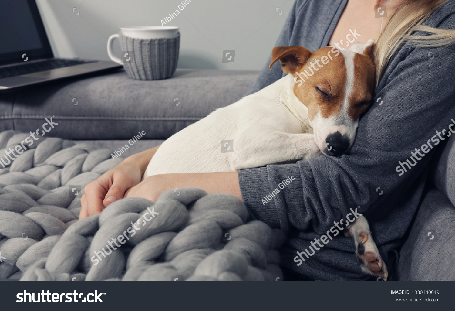 Cozy home woman covered with warm blanket watching movie hugging sleeping dog. Relax carefree comfort lifestyle.
