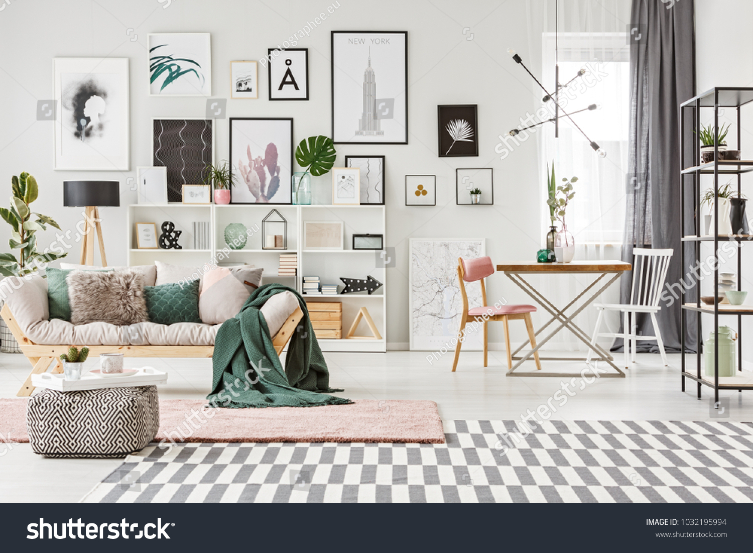 Bright spacious living room interior with table standing next to the window and fresh plants