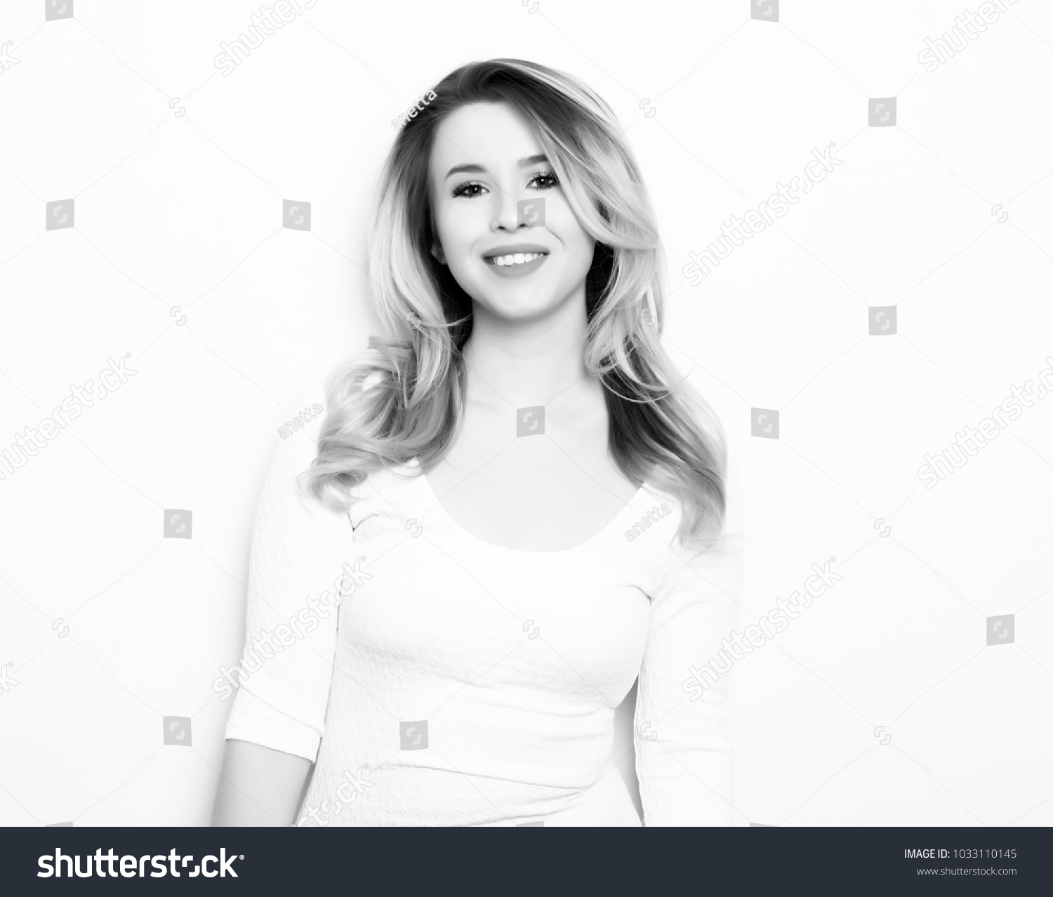 beautiful young blonde woman posing on grey background