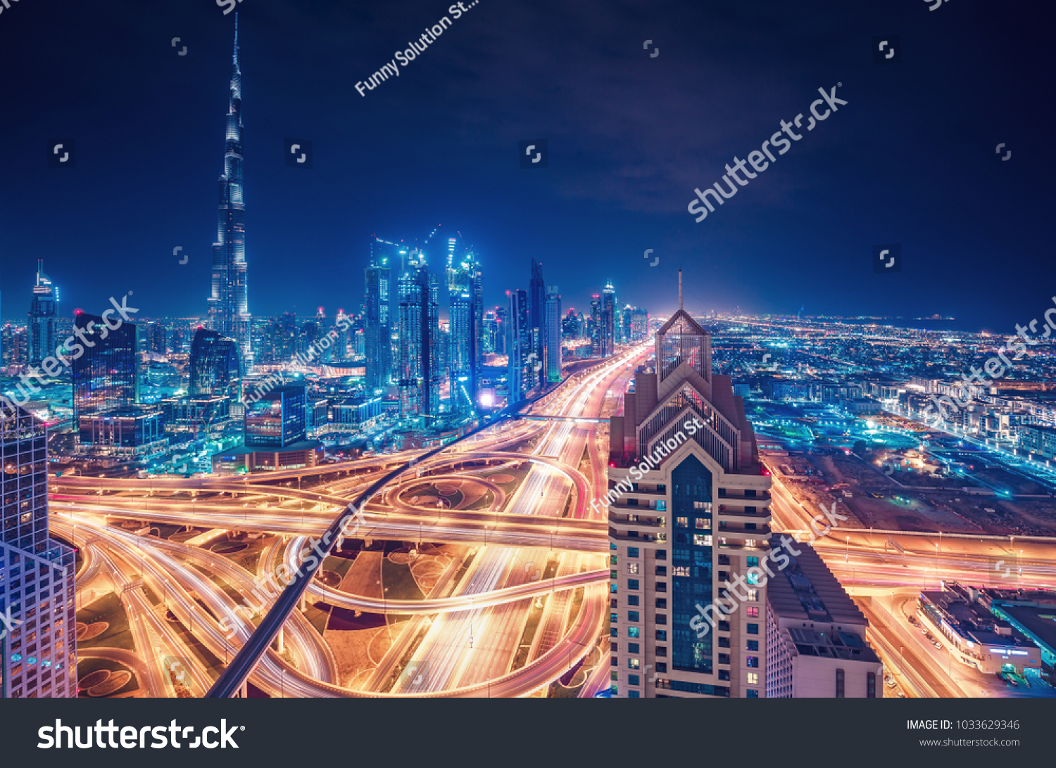 Scenic nighttime skyline of a big modern city. Dubai UAE. Aerial view on famous highway interchange and skyscrapers.