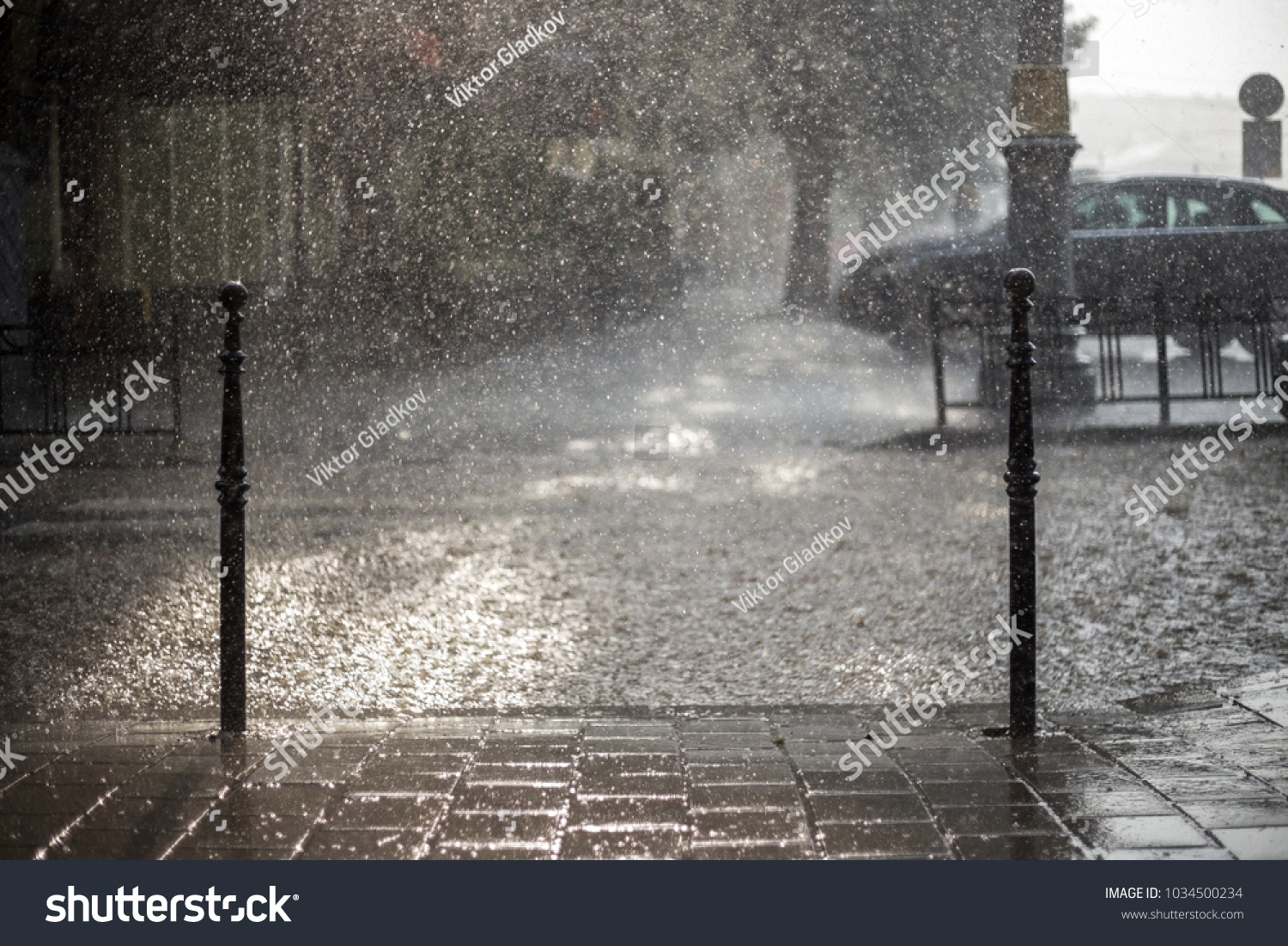 Rain in the city. Road pavement car in rain close up. Water splashes spills on roadway.