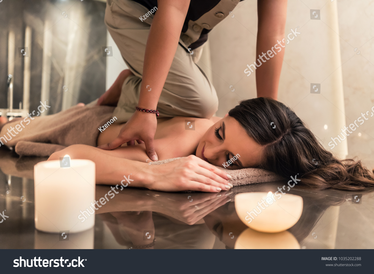 Young woman lying down while enjoying the acupressure techniques of traditional Thai massage at luxury spa and wellness center
