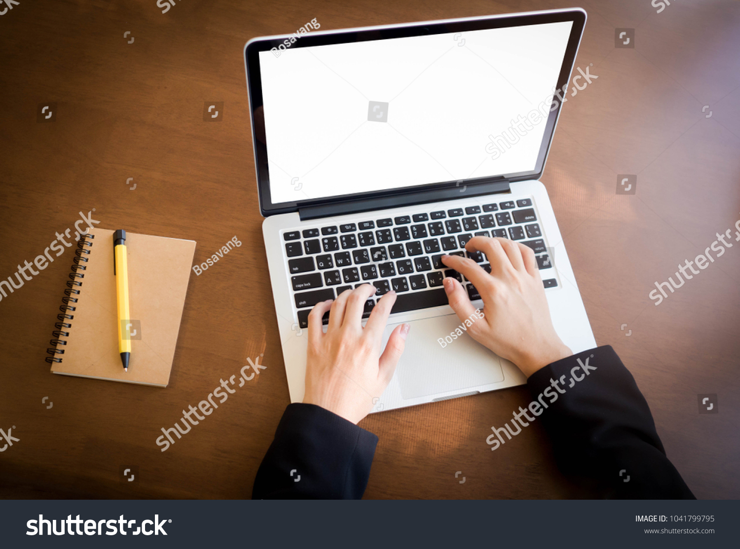 top view  hand typing laptop on desk work with pen on notebook.