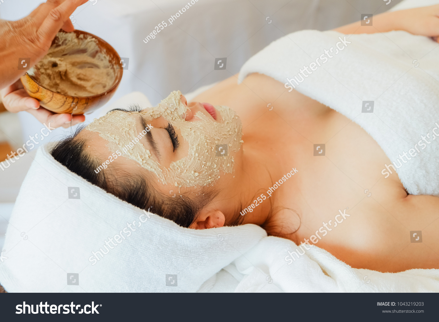 asian woman having face treatment in spa salon on the bed  beauty facial mask