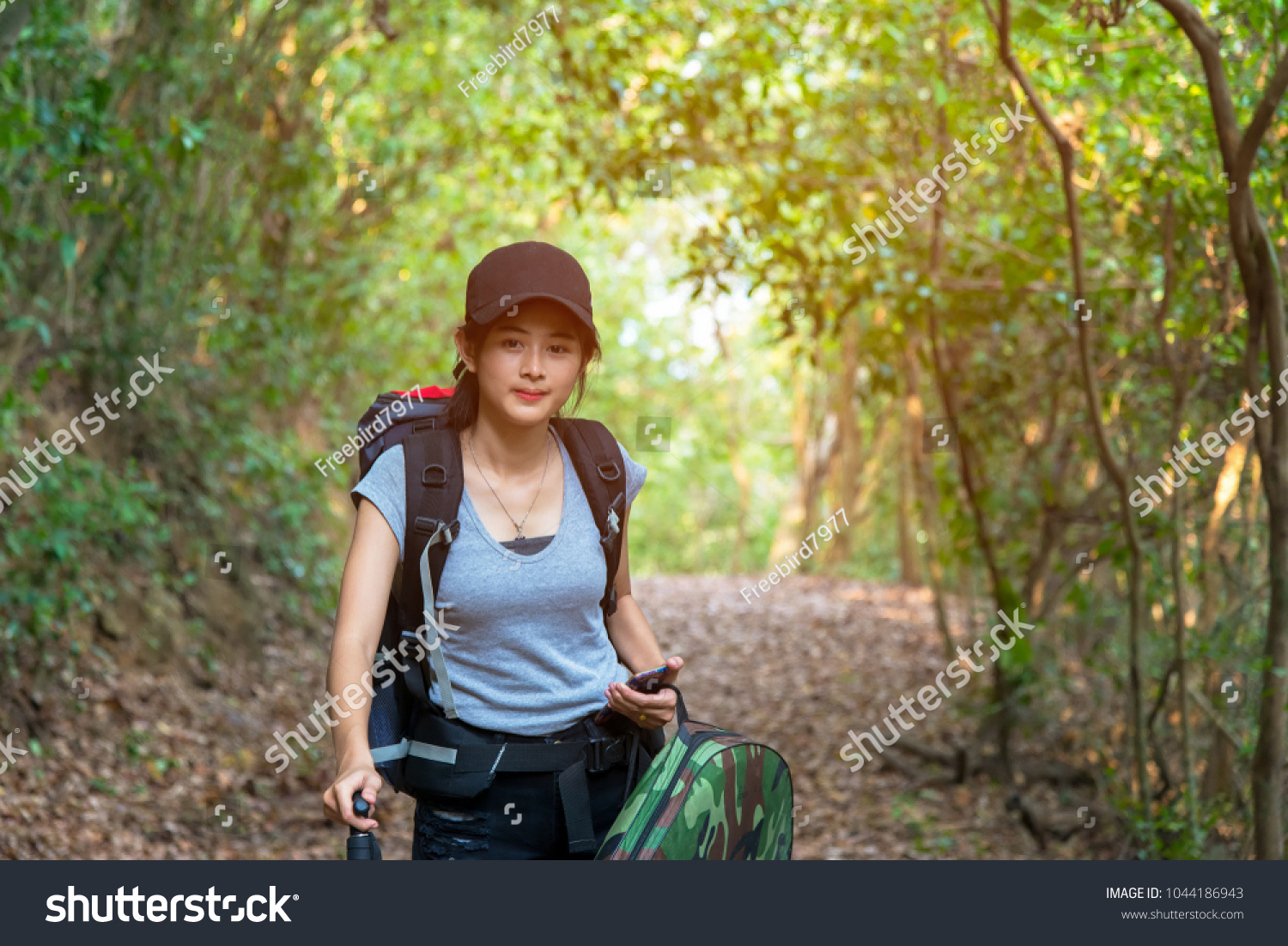 Hiker young women walking in national park with backpack. Woman tourist going camping in forest. Travel Concept