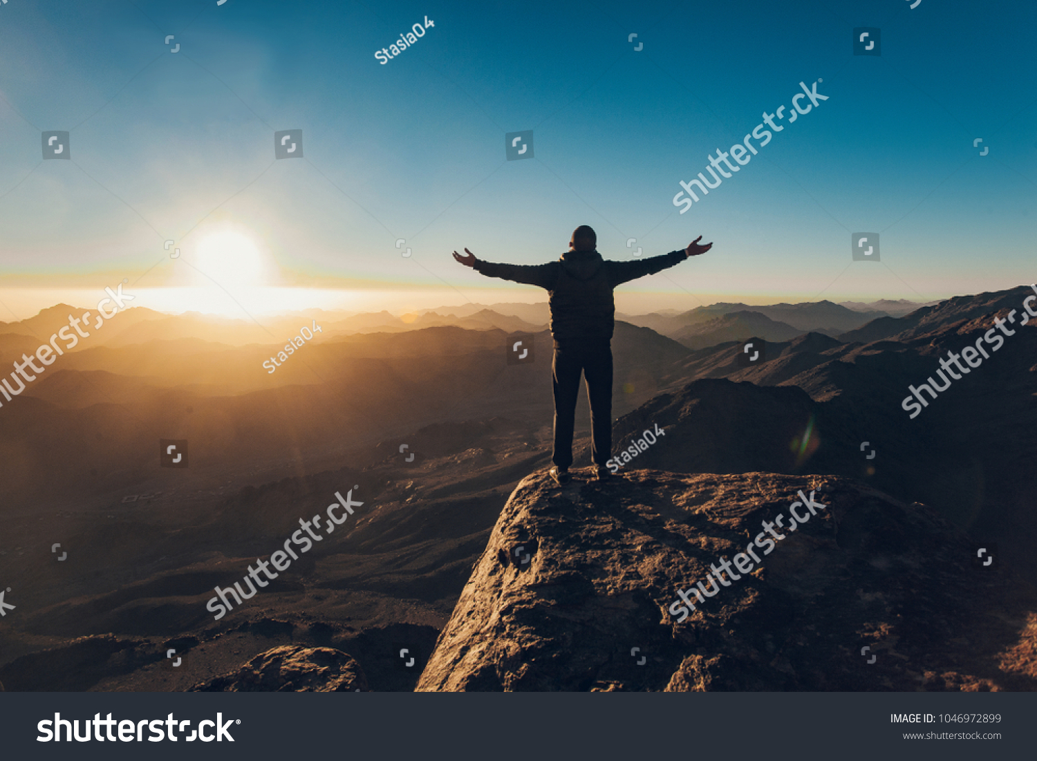 Man stands facing the rising sun and meditates on Mount Sinai in Egypt ...