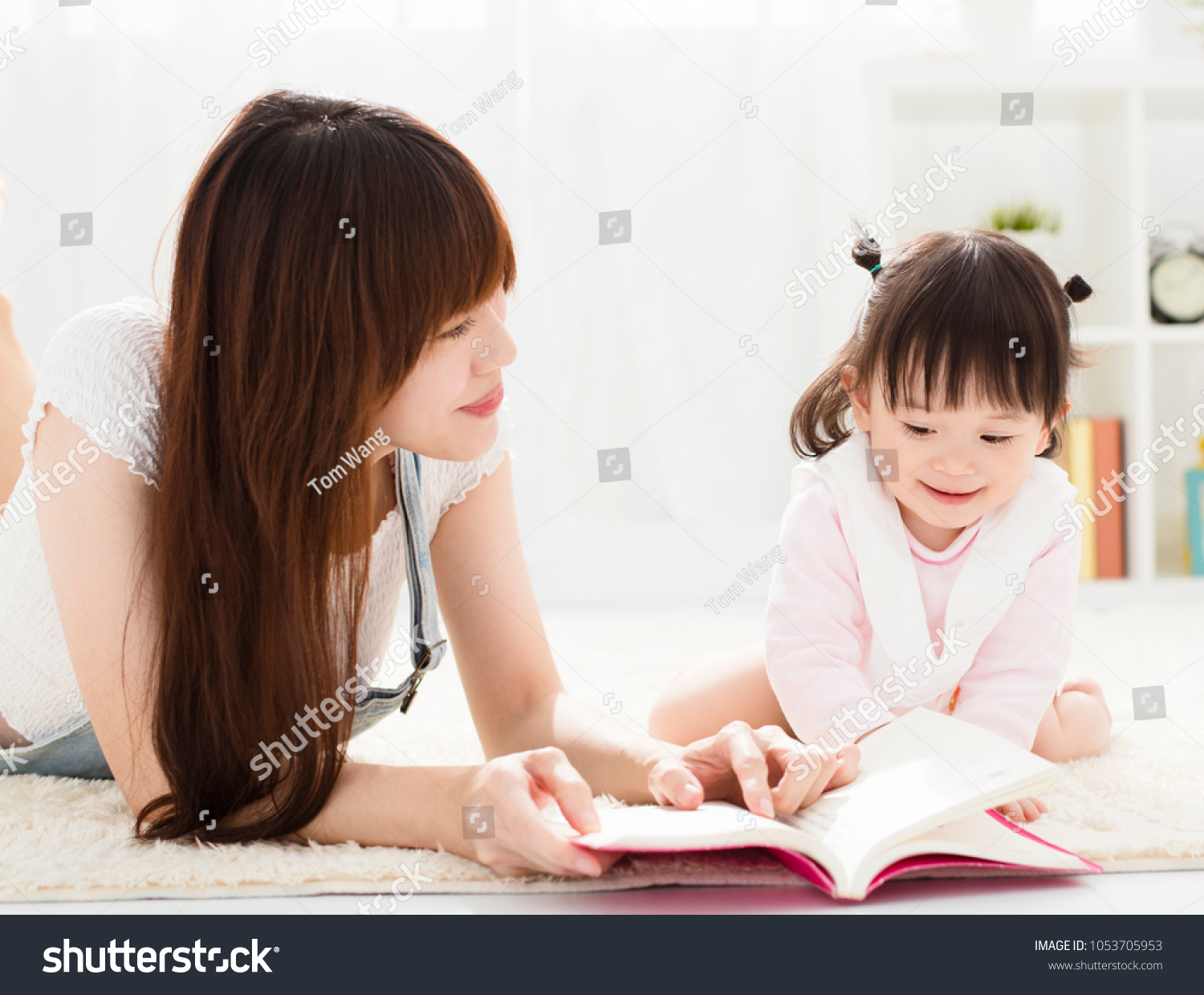 happy Mother reading book to daughter
