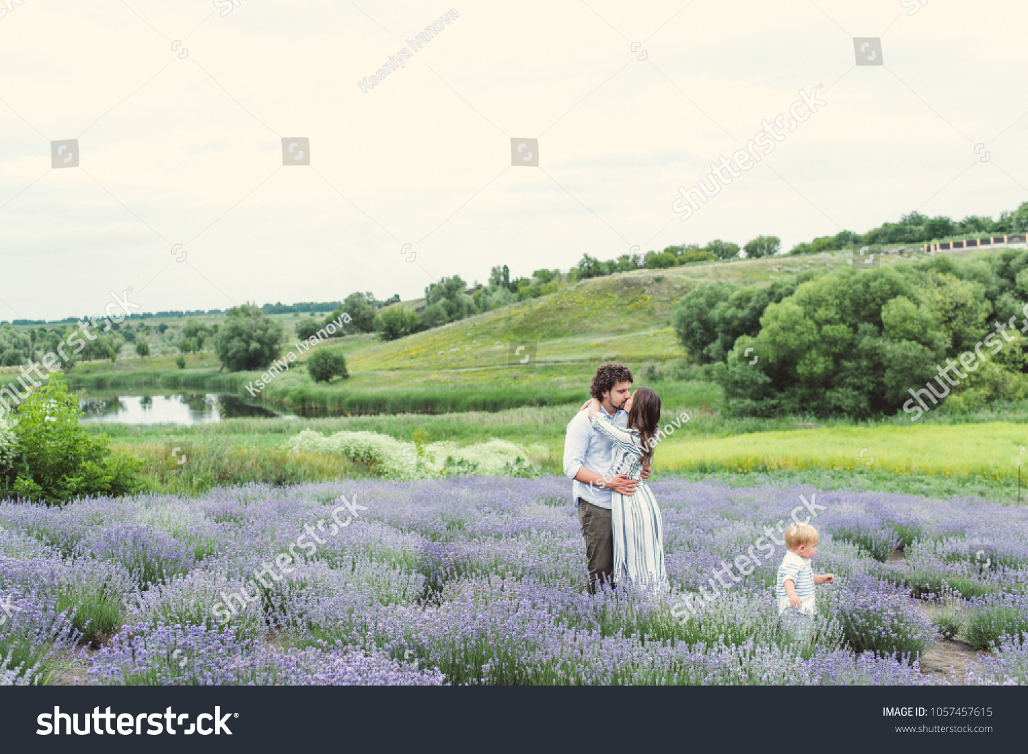 A young couple with a child is walking along the lavender field. Provence. Beautiful field of lavender.