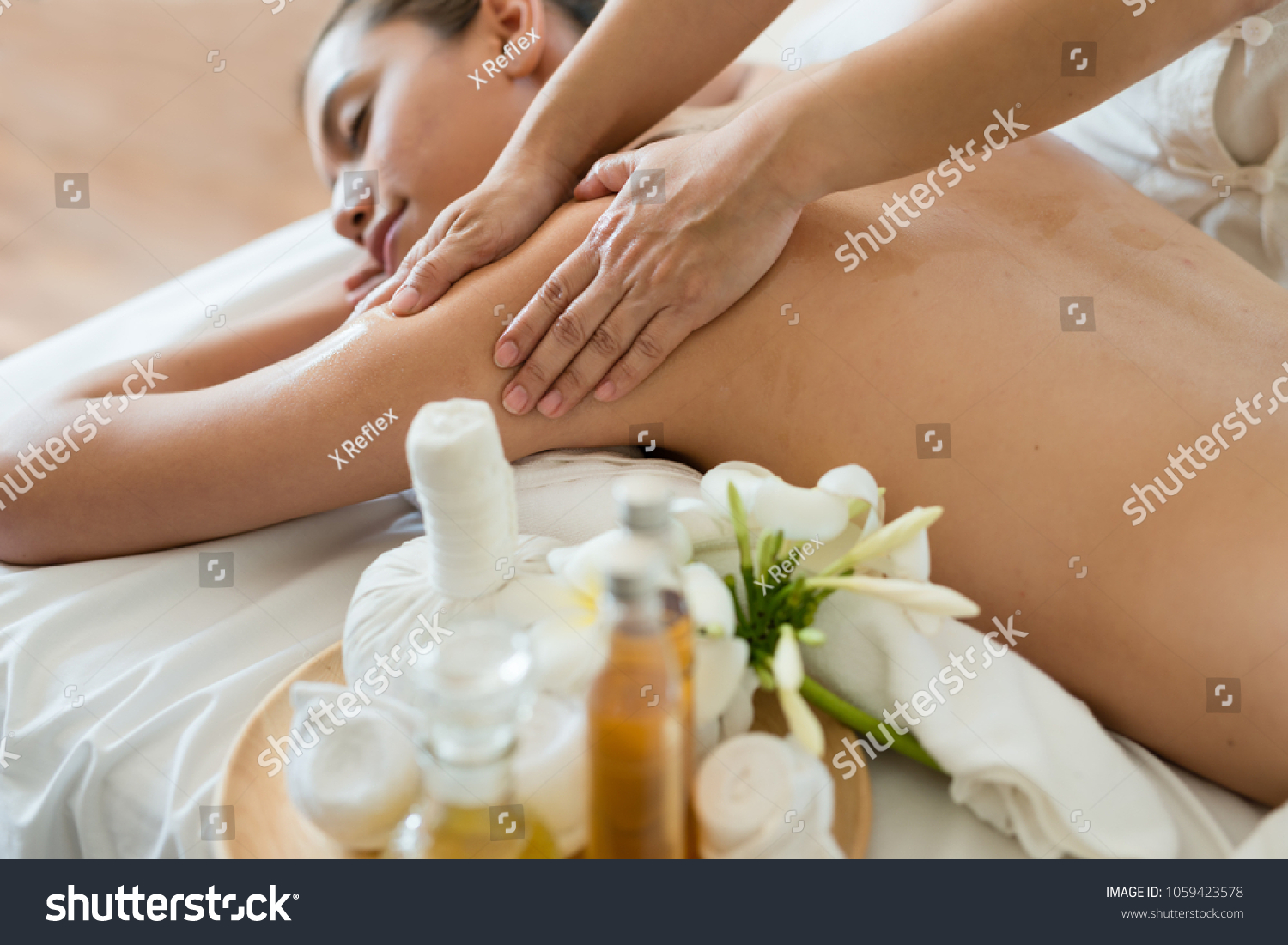 Young beautiful Asian woman sleep relaxing in the Oil spa massage in salon. Select focus hand of masseuse