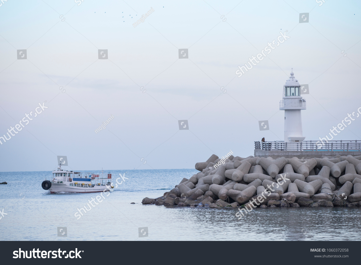 lighthouse. A lighthouse on the coast. A lighthouse on a breakwater. Lighthouse and Tetrapod.