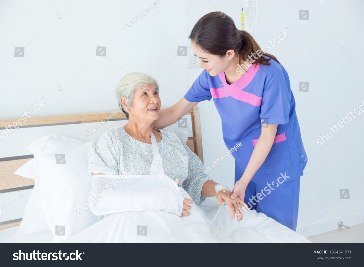 Senior asian female patient smiling with nurse who come to visit her at bed