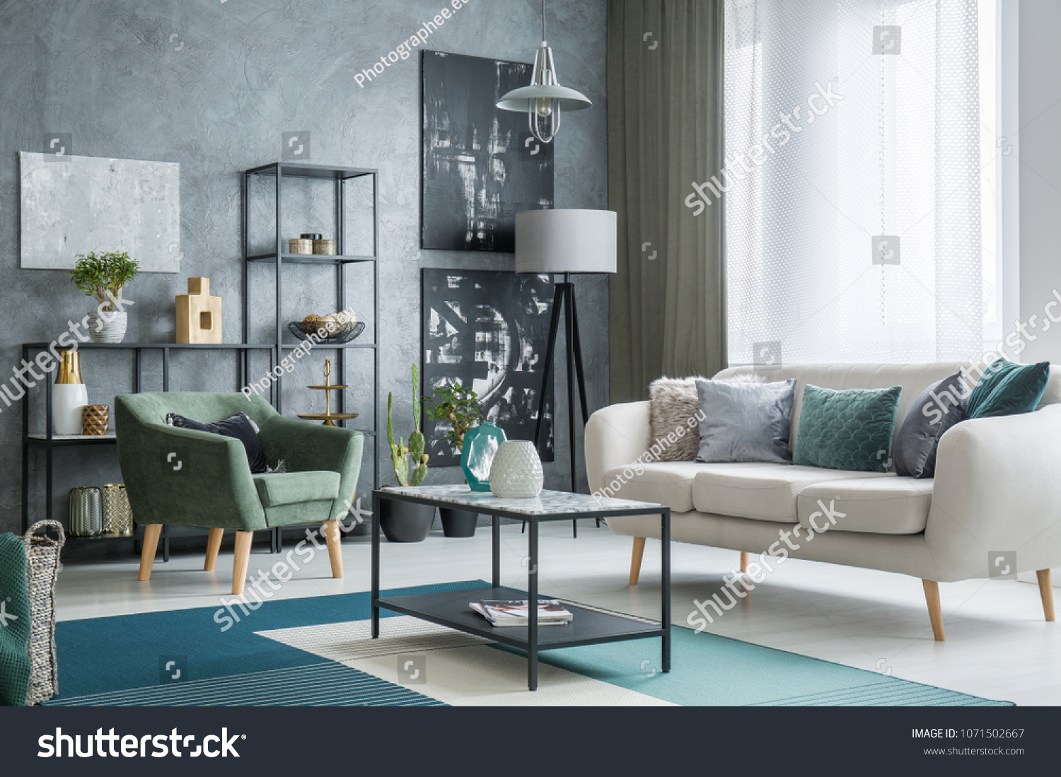 Two dark posters hanging on a grey wall in industrial living room interior with lamps bright couch and table standing on a carpet