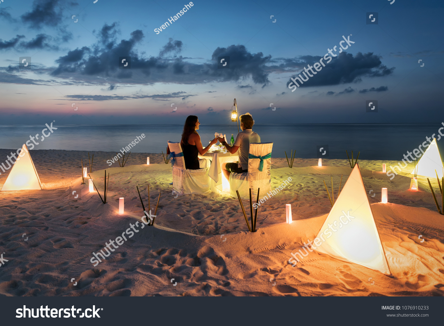 Honeymoon couple is having a private  romantic dinner at a tropical beach