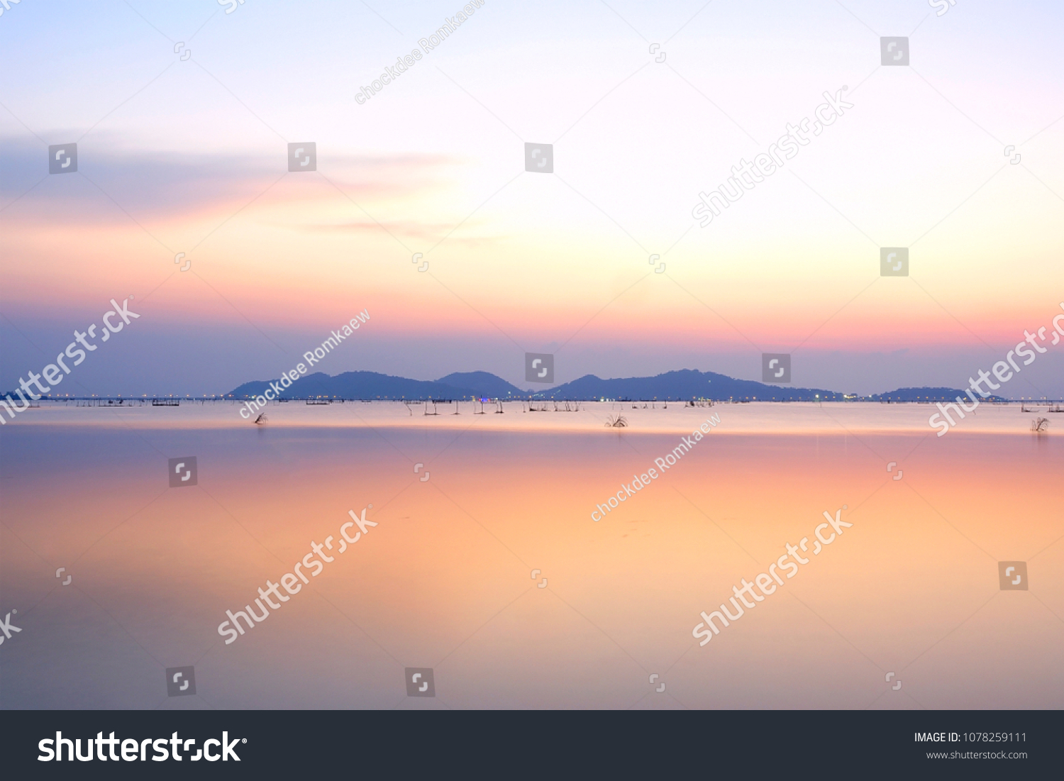 Long exposure shot colored sky on sunset time over island and reflection water background.