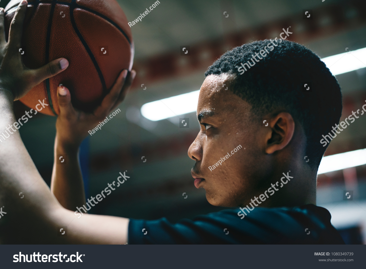 African American teenage boy concentrated on playing basketball