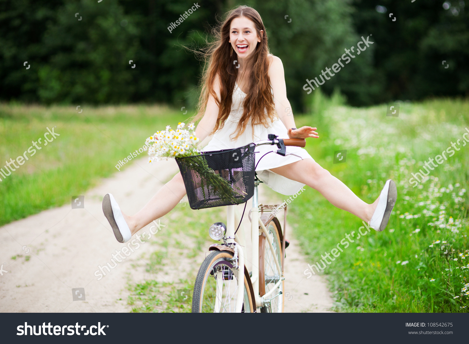 Woman riding bicycle with her legs in the air