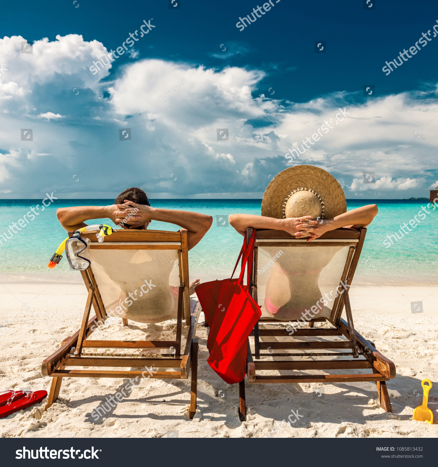Couple in loungers on a tropical beach at Maldives