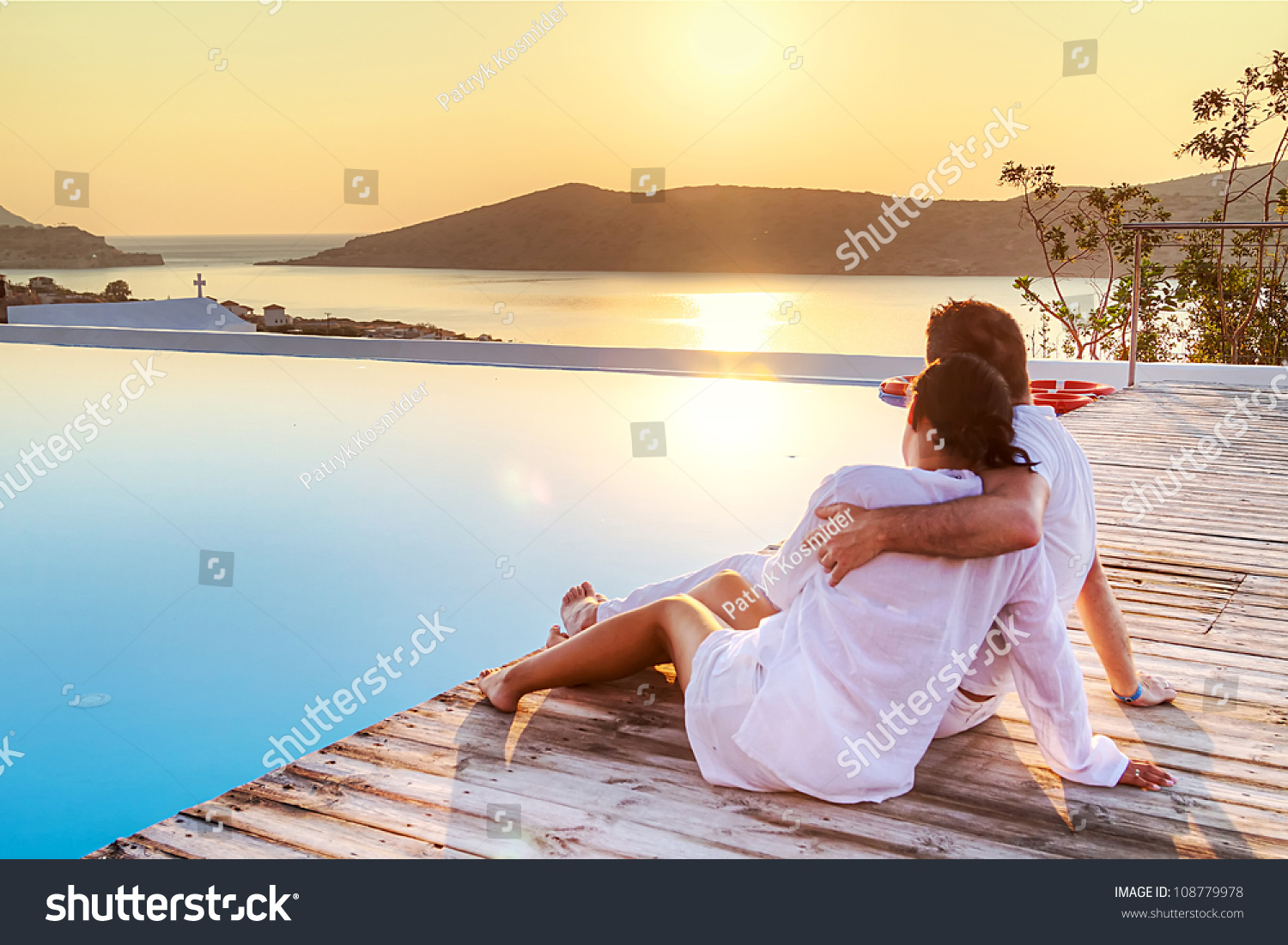 Couple in hug watching sunrise together in Greece