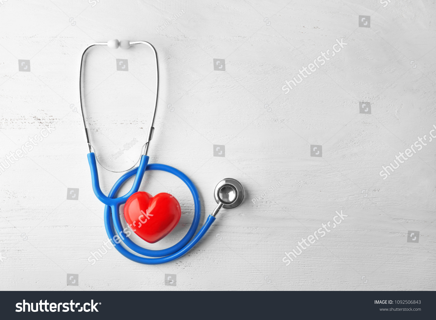 Stethoscope and red heart on white wooden background. Health care concept