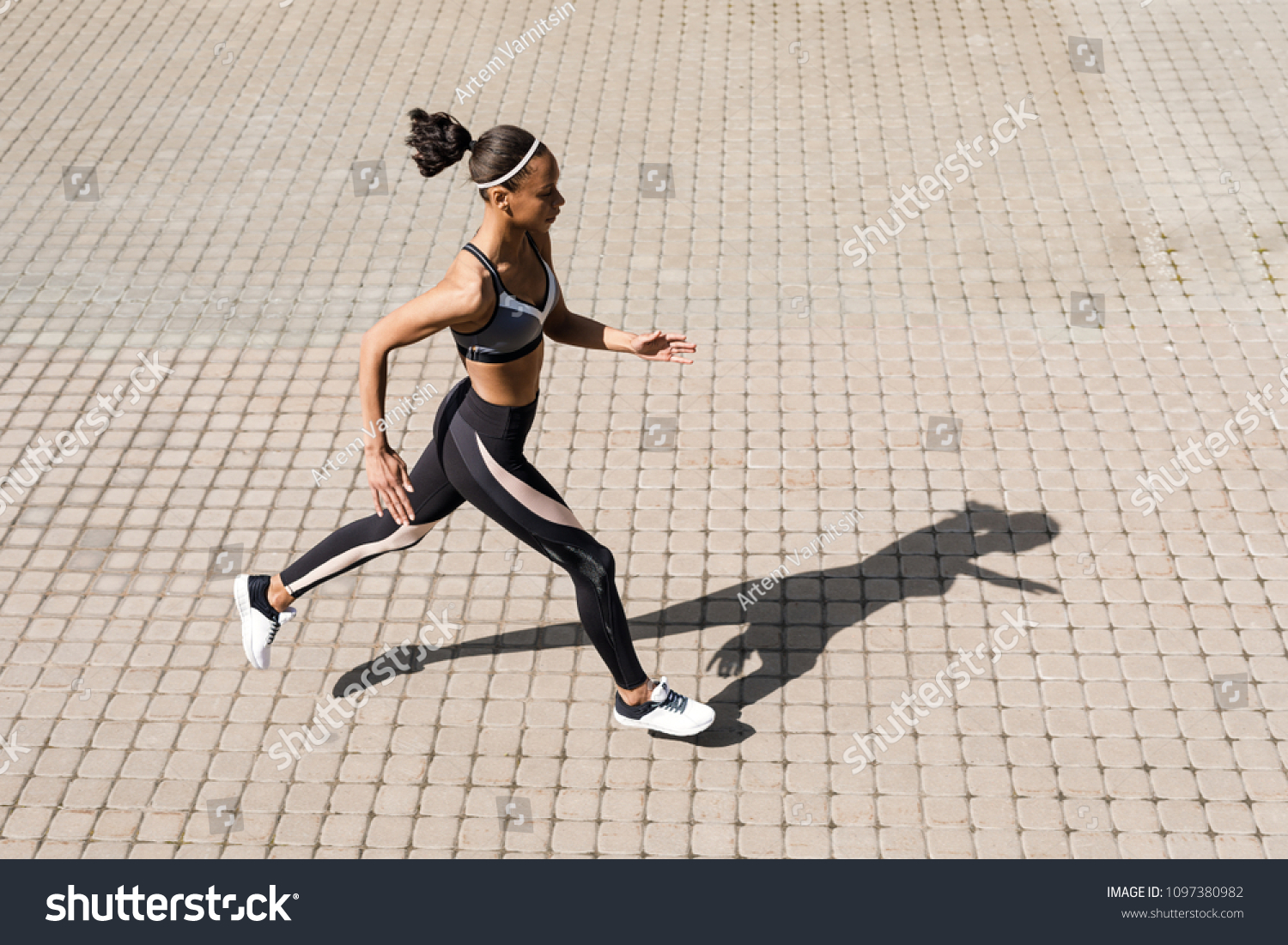 Young woman running on street. Side view of sporty woman exercising ...