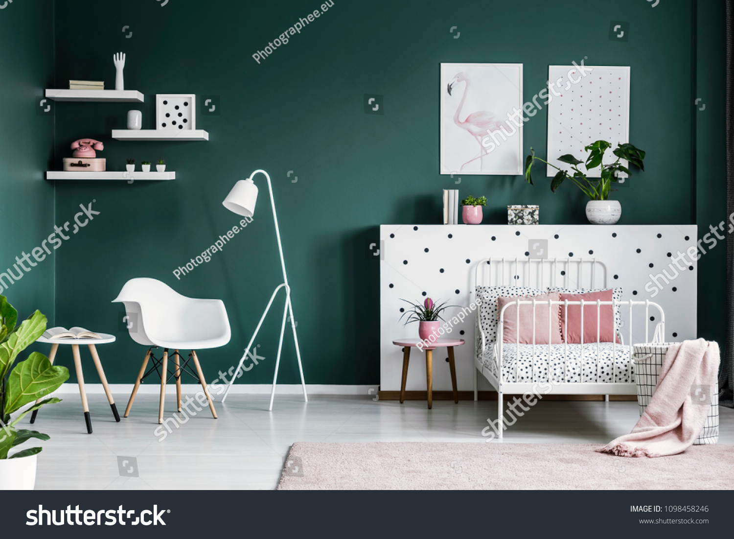 Pastel pink decorations in a scandi bedroom interior for a teenage girl with modern white furniture and dark green walls